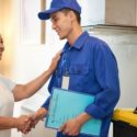 Service personnel in blue uniform assisting a female customer indoors for Walker Plumbing, Heating & Air.