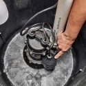 Submersible pump in a sump basin with electrical components, used for HVAC maintenance by Walker Plumbing.
